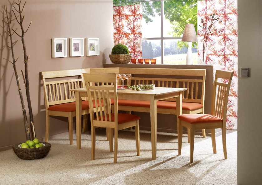 petite-table-de-cuisine-avec-banc-d'angle-rembourré-en-orange-couleur-et-deux-accoudoirs