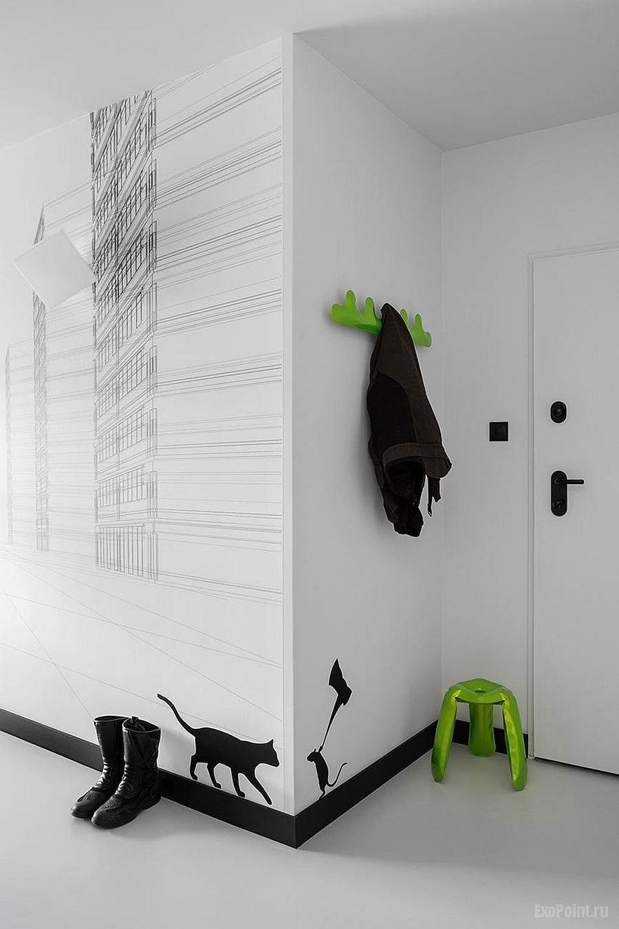 décalcomanies murales en noir et blanc et touches de vert vives vous souhaitent la bienvenue à l'entrée de l'appartement