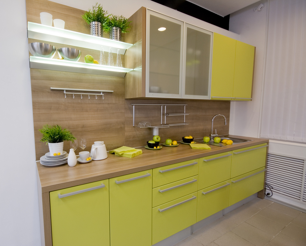 petite-cuisine-design-presentant-jaune-vert-finition-armoires-de-cuisine-avec-poignées-de-tirage-nickel-brossé-et-comptoir-en-bois-sous-mur-armoires de cuisine-utilisant-une-porte-en-verre-dépoli