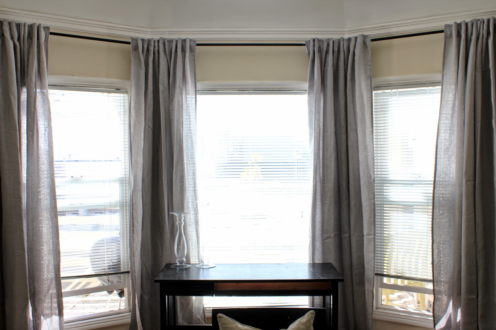 blanc-encadré-large-fenêtre-mélangé-avec-ikea-rideaux-en-gris-clair-aussi-transparent-vase-fleur-sur-table-en-bois-brillant