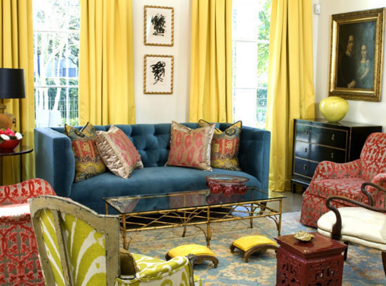 mur-blanc-avec-fenêtres-en-verre-et-longs-rideaux-jaunes-combinés-avec-canapé-bleu-rouge-aussi-coussins-plus-rectangle-table-en-verre-sur-le-tapis-bleu-crème
